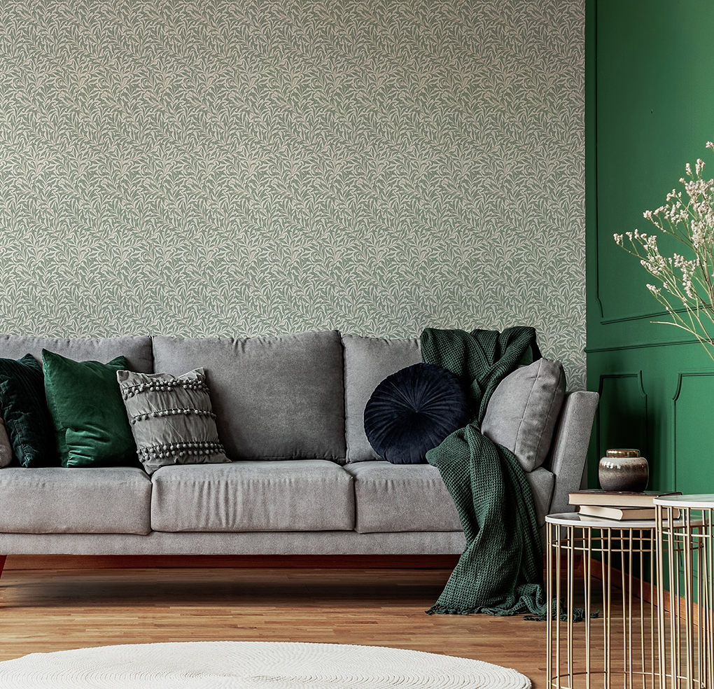 Giấy dán tường họa tiết hoa màu tím và nâu trong phòng khách, ghế sofa màu xám, ghế bành màu xanh và bàn cà phê mặt đá cẩm thạch có chân thép màu đen.