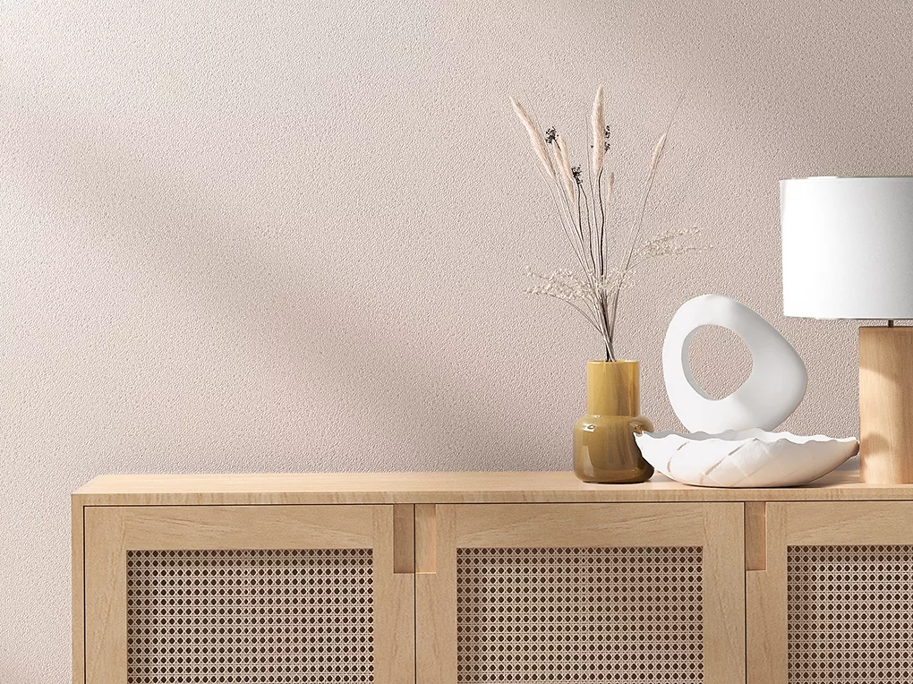 Giấy dán tường in hình lá xanh trong phòng khách có ghế sofa màu xanh lá cây.