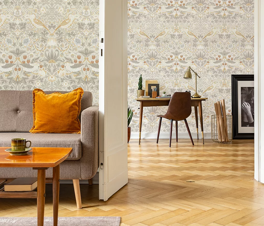 Giấy dán tường hoa trong phòng khách với bàn gỗ và tranh nghệ thuật thực vật có khung vàng, bát kim loại và cây trong chậu hiệu ứng vàng.