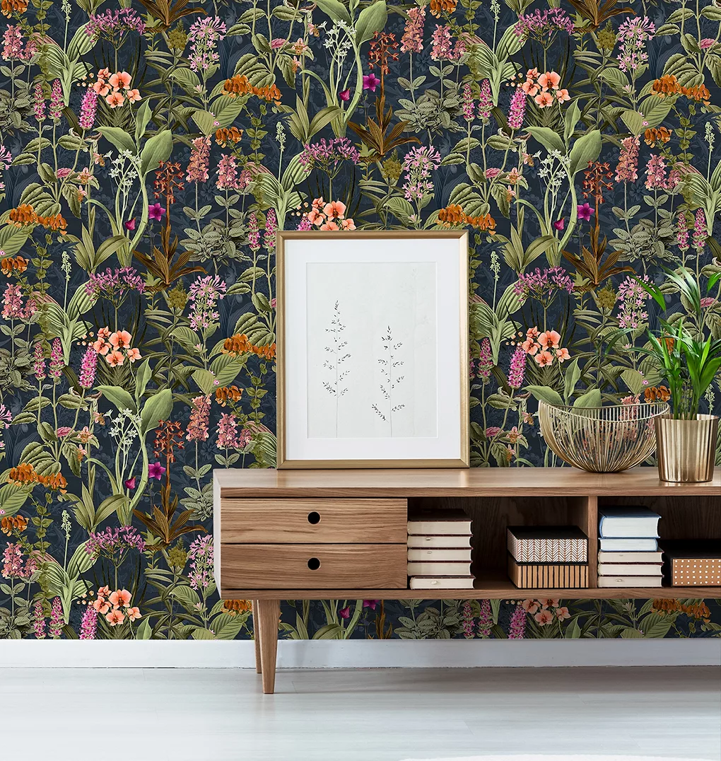 Giấy dán tường nổi màu kem ở nửa trên của tường và tấm gỗ màu trắng ở nửa dưới của tường trong phòng khách với ghế bành màu kem và đệm hoa màu hồng.