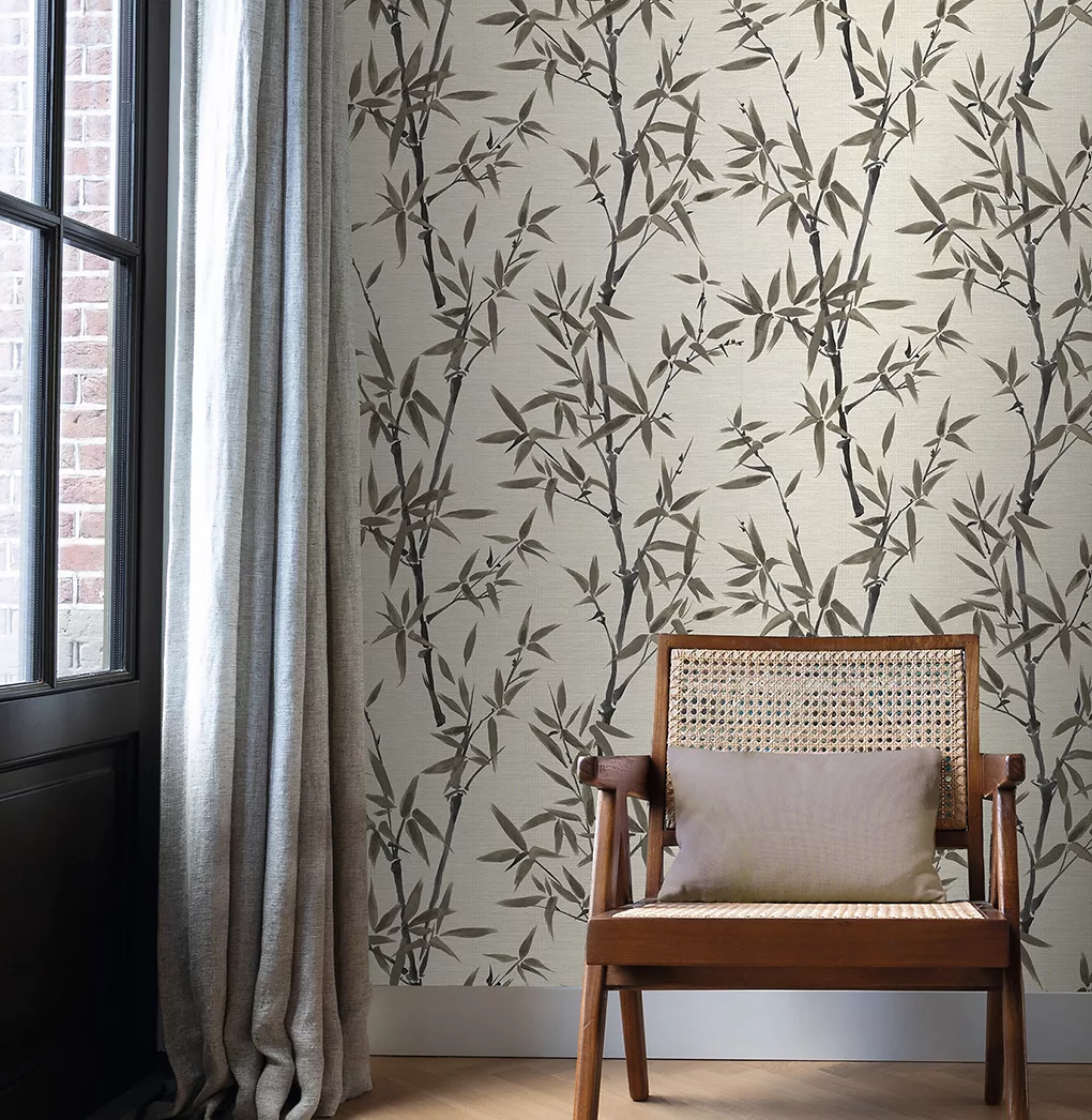 Phòng khách hiện đại được trang trí bằng giấy dán tường họa tiết lá xanh, ghế sofa màu xám nhạt, ghế bành bằng gỗ và bàn cà phê.