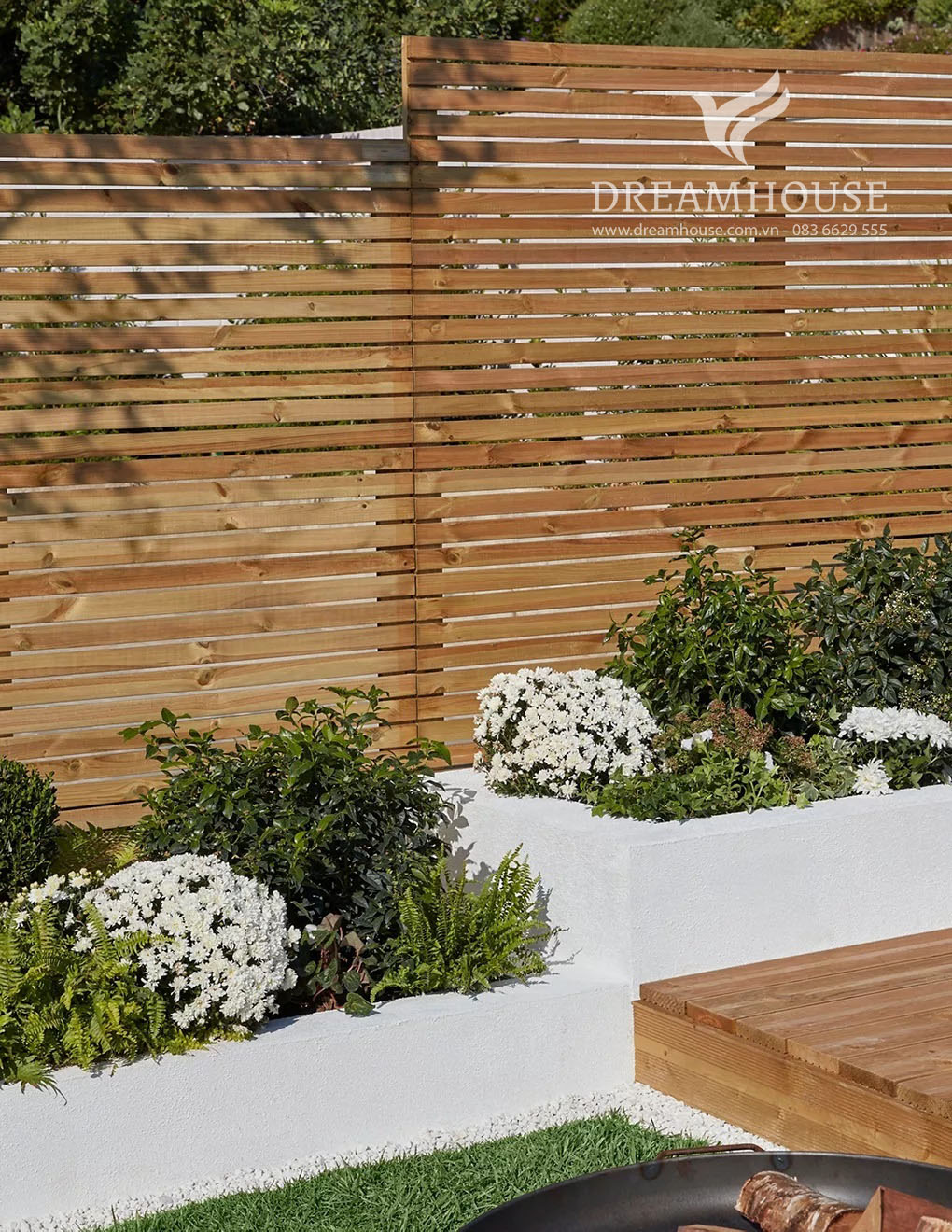 35-y-tuong-thiet-ke-canh-quan-san-vuon-cho-nam-2025-cho-nguoi-dam-me-2 Những luống vườn cao bằng đá trắng đầy cây bụi và hoa.