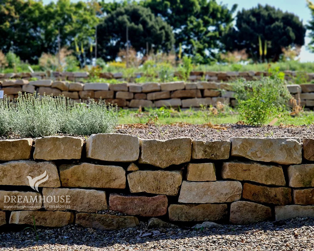 35-y-tuong-thiet-ke-canh-quan-san-vuon-cho-nam-2025-cho-nguoi-dam-me-20 Khu vườn dốc được biến đổi bằng những bức tường đá thô sơ, tạo nên nhiều tầng và biến địa hình không bằng phẳng thành không gian ngoài trời tiện dụng và đẹp mắt.