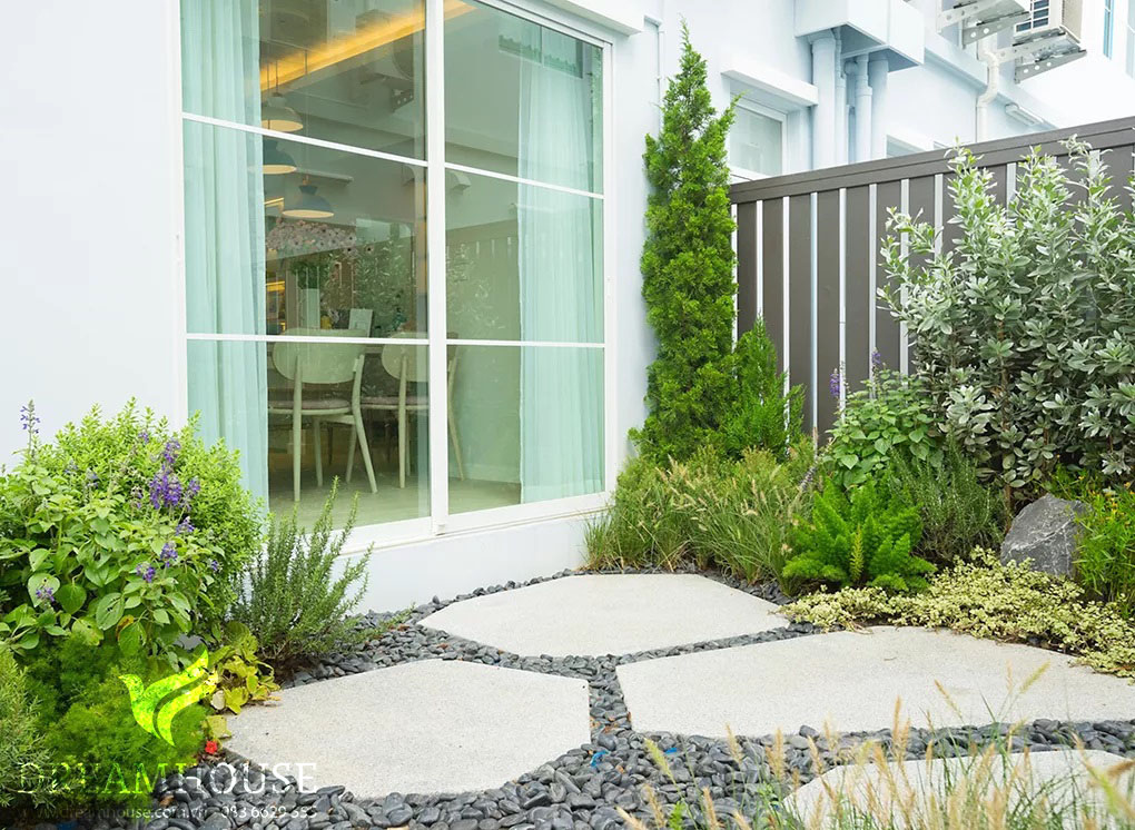 35-y-tuong-thiet-ke-canh-quan-san-vuon-cho-nam-2025-cho-nguoi-dam-me-23 Những viên đá bước màu trắng đặt trên sỏi màu xám đậm, tạo nên lối đi thanh lịch với độ tương phản nổi bật và là điểm nhấn quyến rũ trong khu vườn.