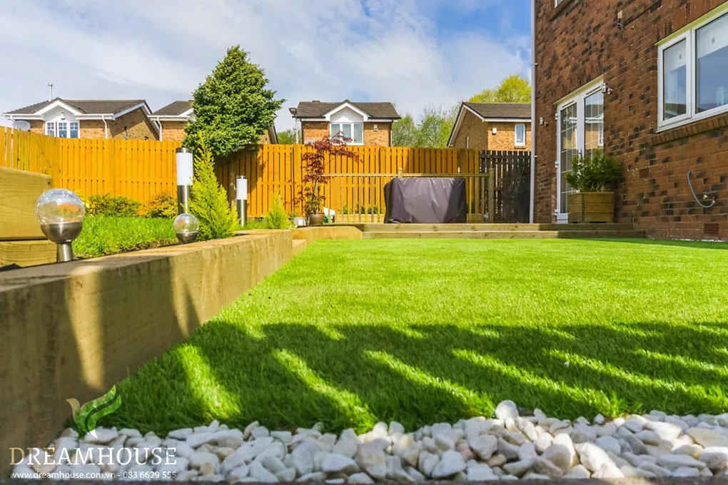 35-y-tuong-thiet-ke-canh-quan-san-vuon-cho-nam-2025-cho-nguoi-dam-me-27 Khu vườn hiện đại với thiết kế tối giản, có bãi cỏ được chăm sóc tốt, luống cao và những viên sỏi trắng bóng tạo nên không gian hiện đại, ít cần bảo dưỡng.