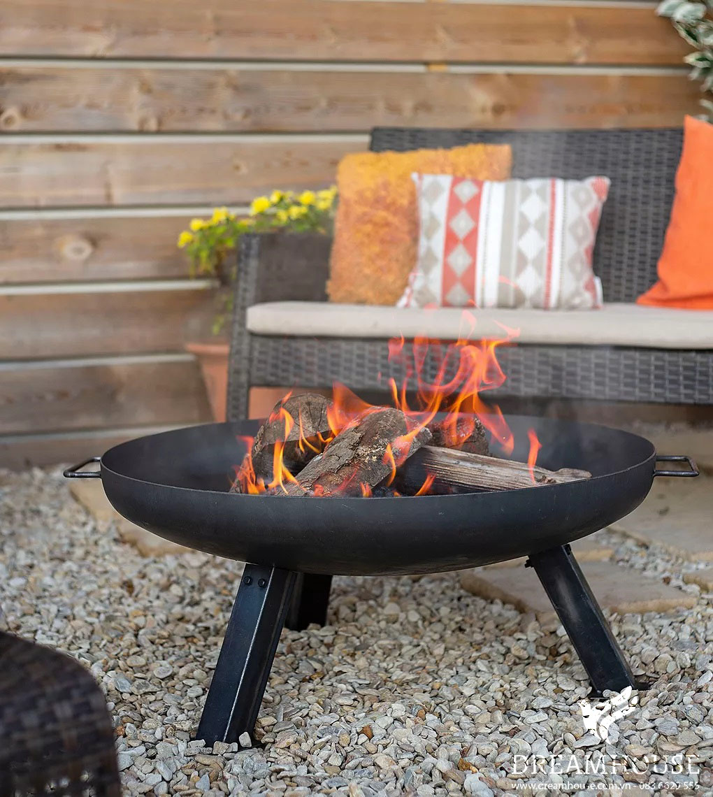 35-y-tuong-thiet-ke-canh-quan-san-vuon-cho-nam-2025-cho-nguoi-dam-me-33 Hố lửa đen chứa đầy củi đang cháy, tỏa ra ánh sáng ấm áp khắp khu vườn.