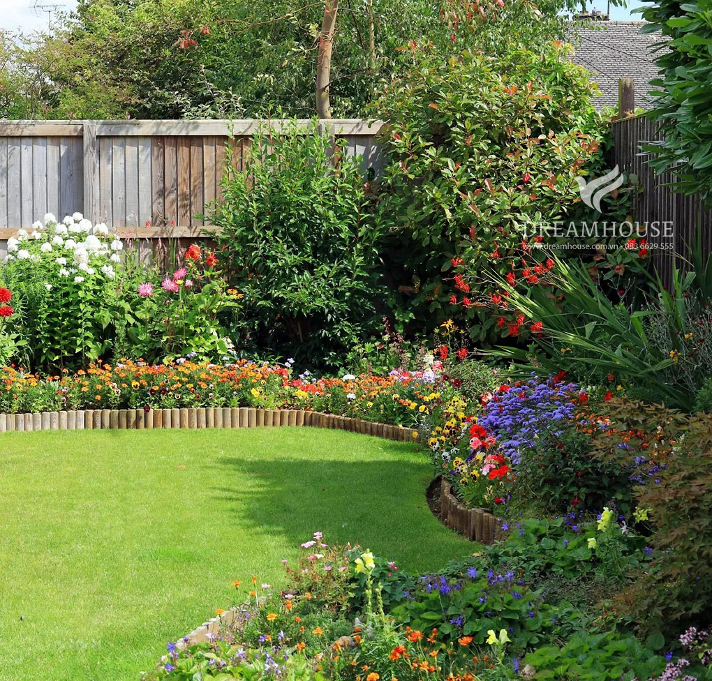 35-y-tuong-thiet-ke-canh-quan-san-vuon-cho-nam-2025-cho-nguoi-dam-me-6 Khu vườn được phân tầng với các bông hoa ở tiền cảnh, cây bụi ở giữa và cây ở hậu cảnh, tạo thêm chiều sâu, cấu trúc và màu sắc cho khu vườn.